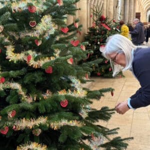 Susan decorating the Christmas tree with heart shaped decorations and sparkling tinsel